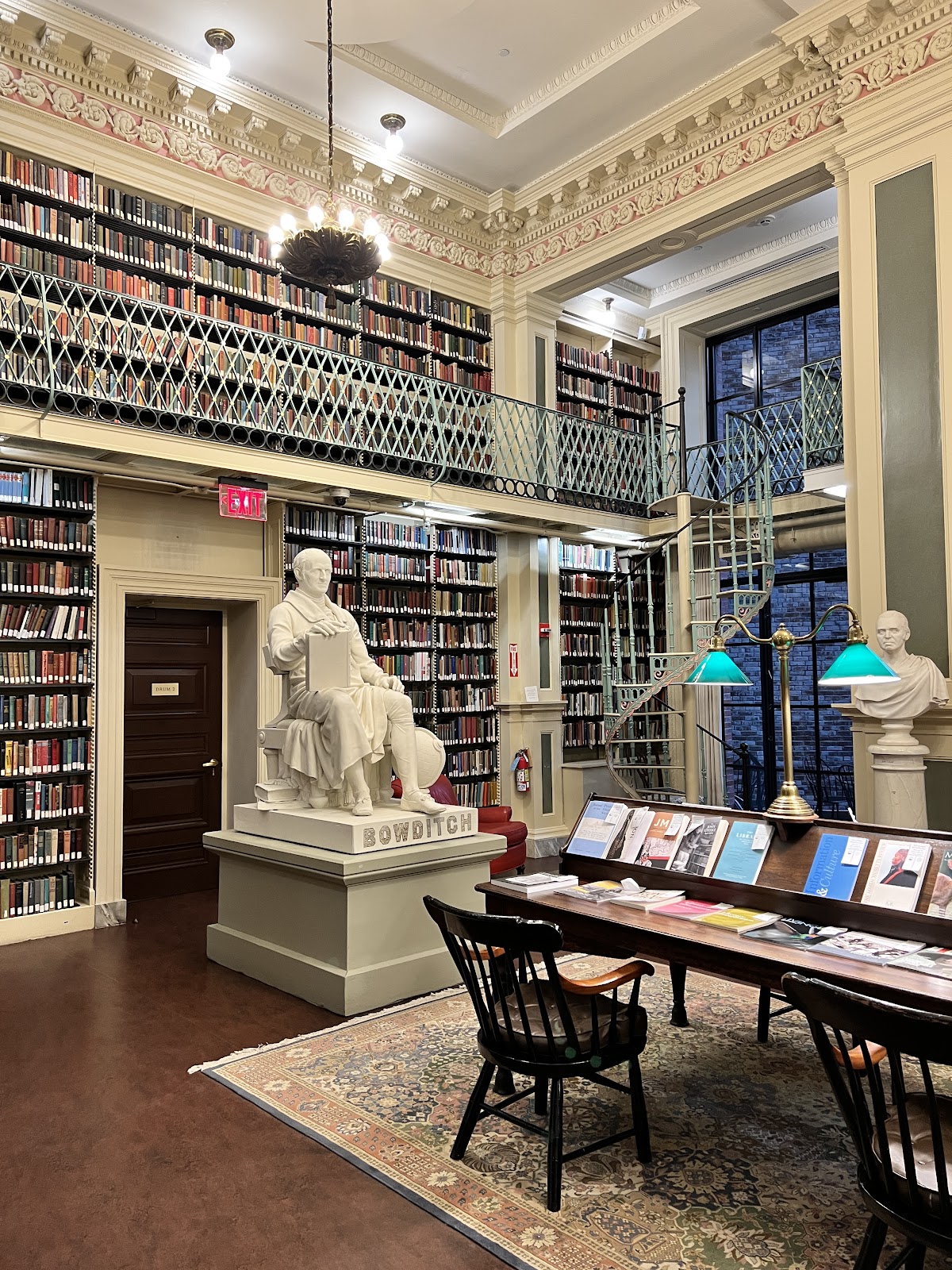 Wedding portrait with library book stacks receding behind the couple at the Boston Athenaeum