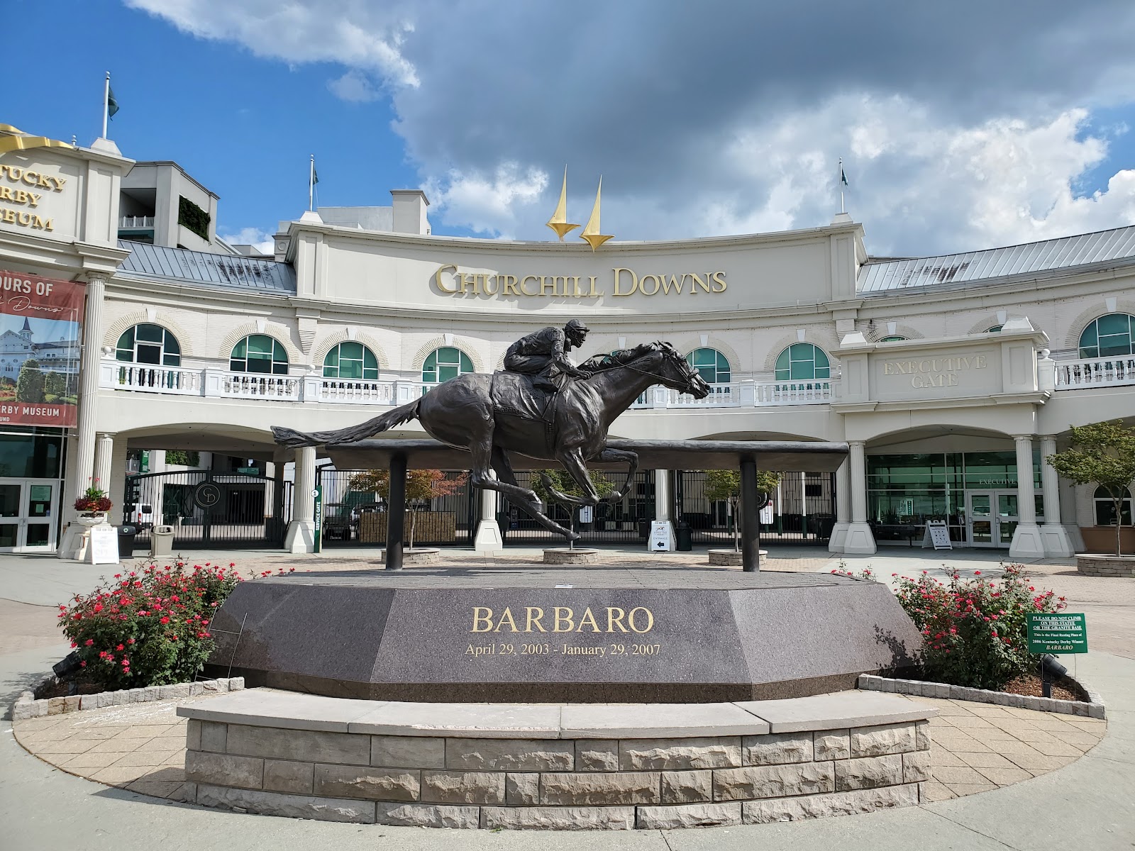 Twin spires of Churchill Downs photographed with a long lens so they read large behind a wedding couple