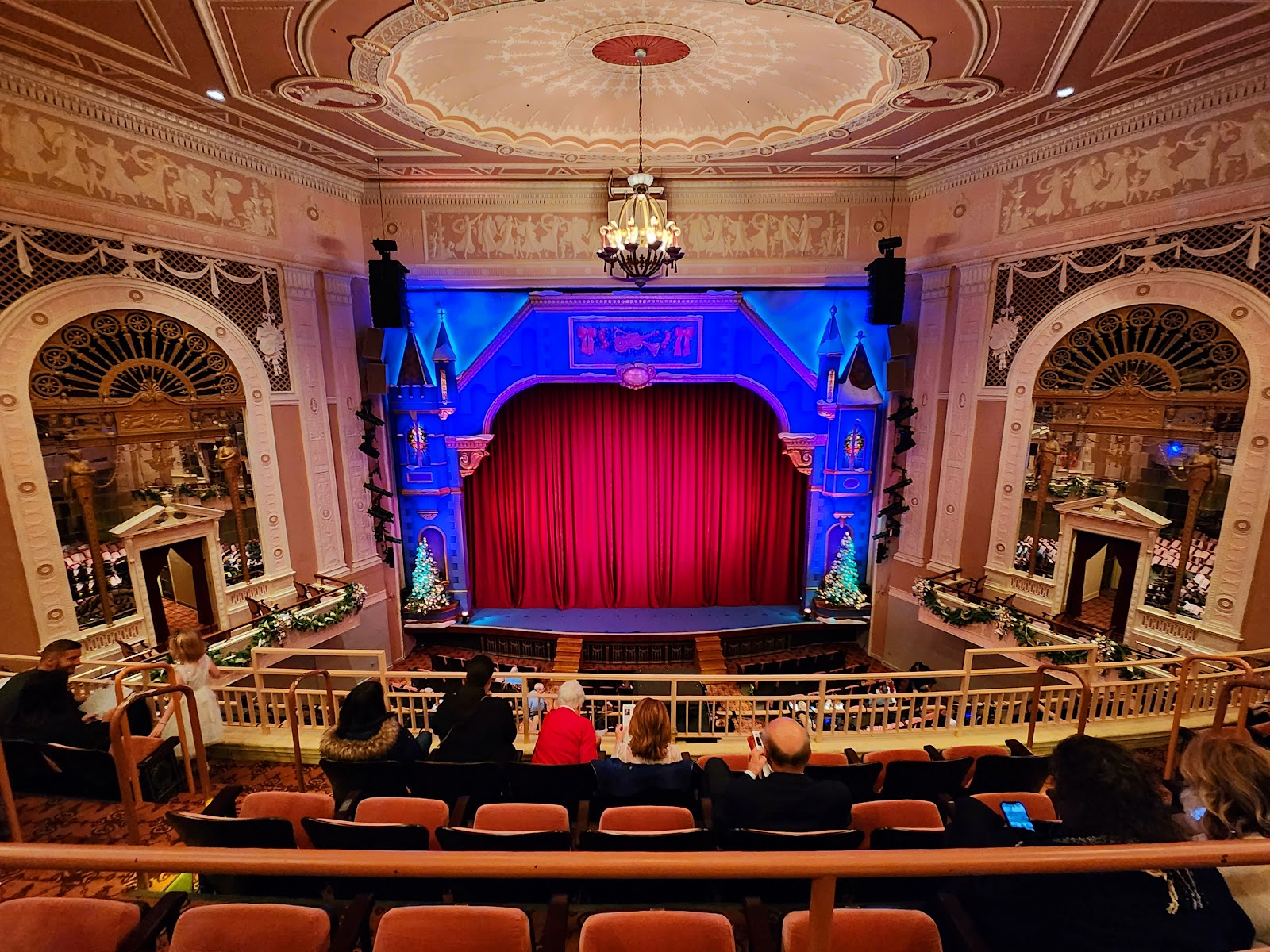 Looking out from a stage into a dark auditorium with boxes above