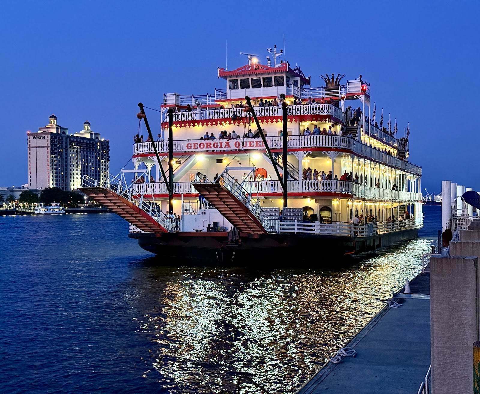 Wedding couple at the rail of a Savannah riverboat with wind moving the veil
