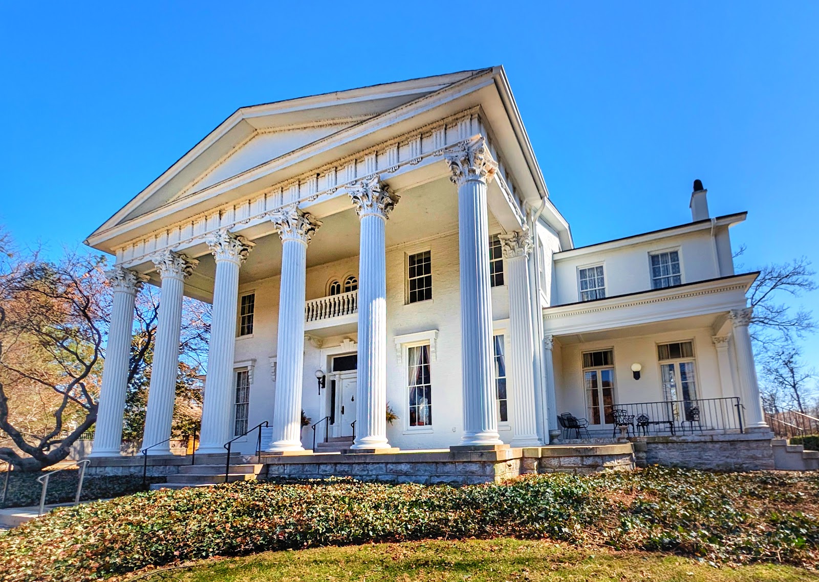 Wedding portrait in portico shade at Whitehall Mansion with the sunlit white facade acting as a reflector