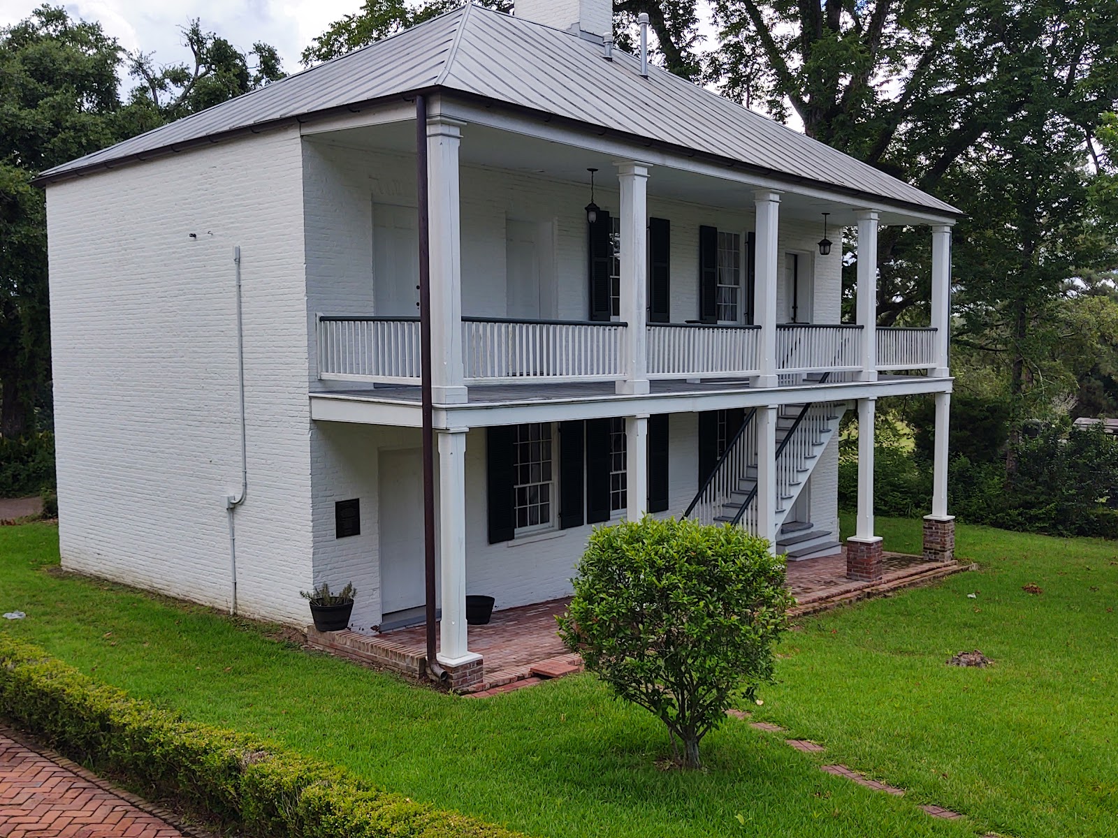 Deep columned portico giving hard-edged shade at a Natchez mansion