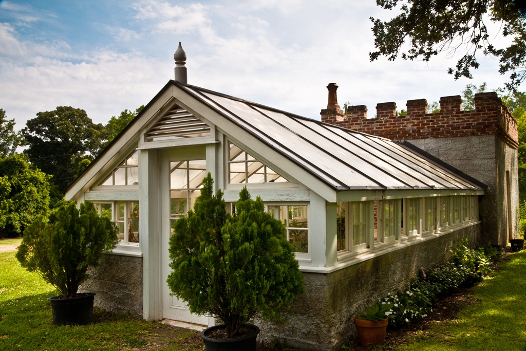 Deep covered gallery with hard-edged shade and a bright lawn beyond