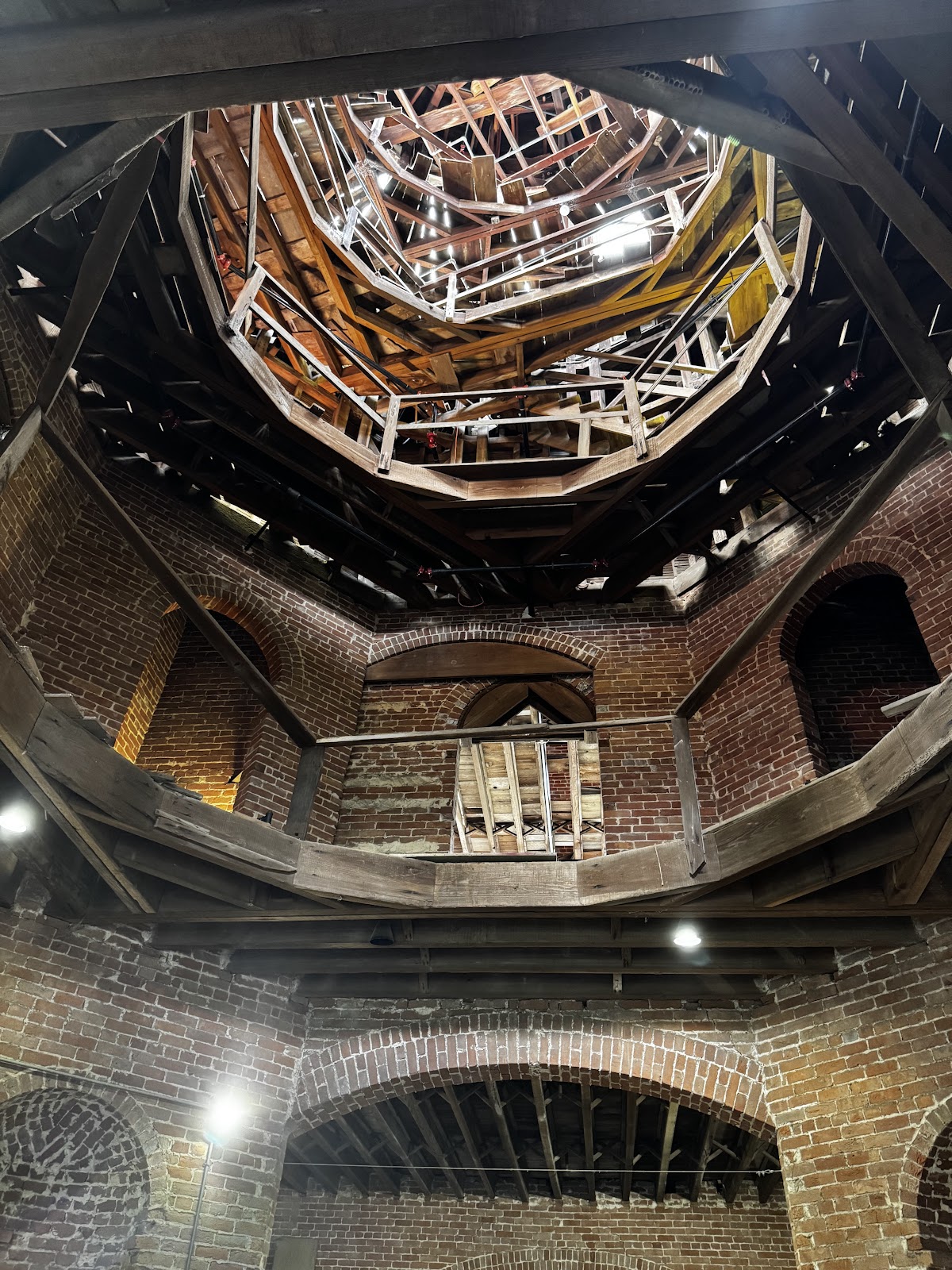 Couple lit at the margin of a daylight shaft inside a bare masonry interior