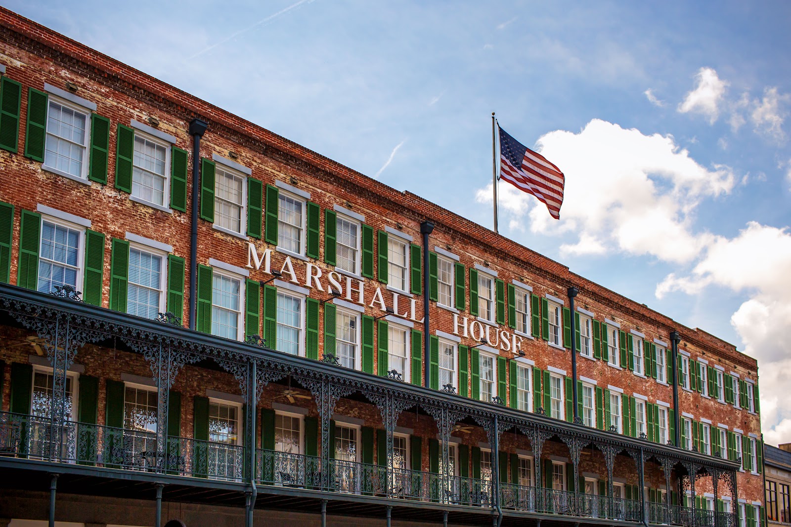 Low afternoon light raking across cast-iron scrollwork at the Marshall House, Savannah