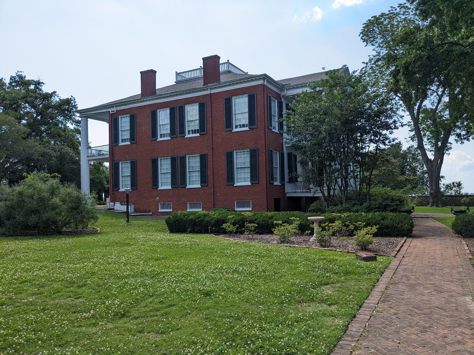 Deep columned portico giving hard-edged shade with a bright view beyond