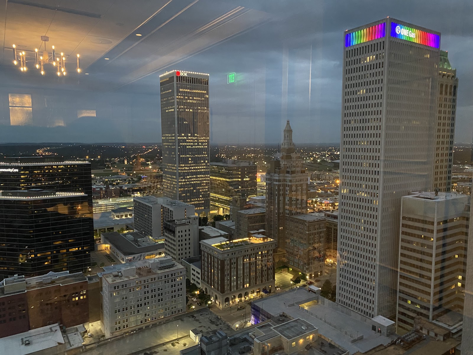 Wedding couple lit with flash against Tulsa city lights at dusk from The Summit Club