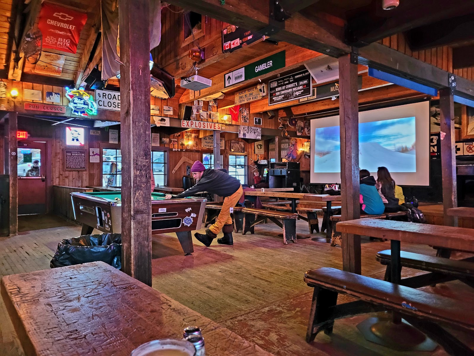 Warm low tungsten ambient light in a bar interior with visible grain
