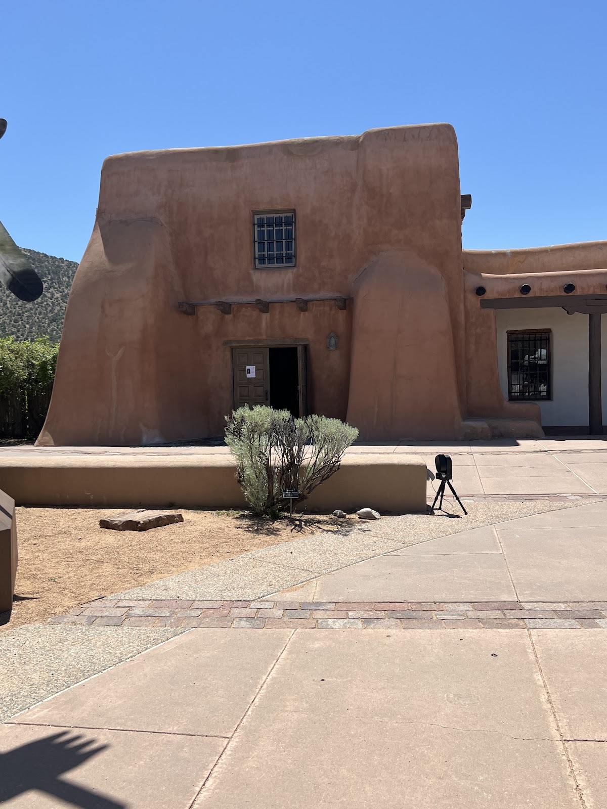 Deep shade with warm bounce beside an adobe-form museum wall on Museum Hill, Santa Fe