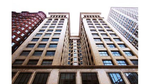 Intricate low-relief terracotta ornament on the Union Trust Building lit by raking low sun