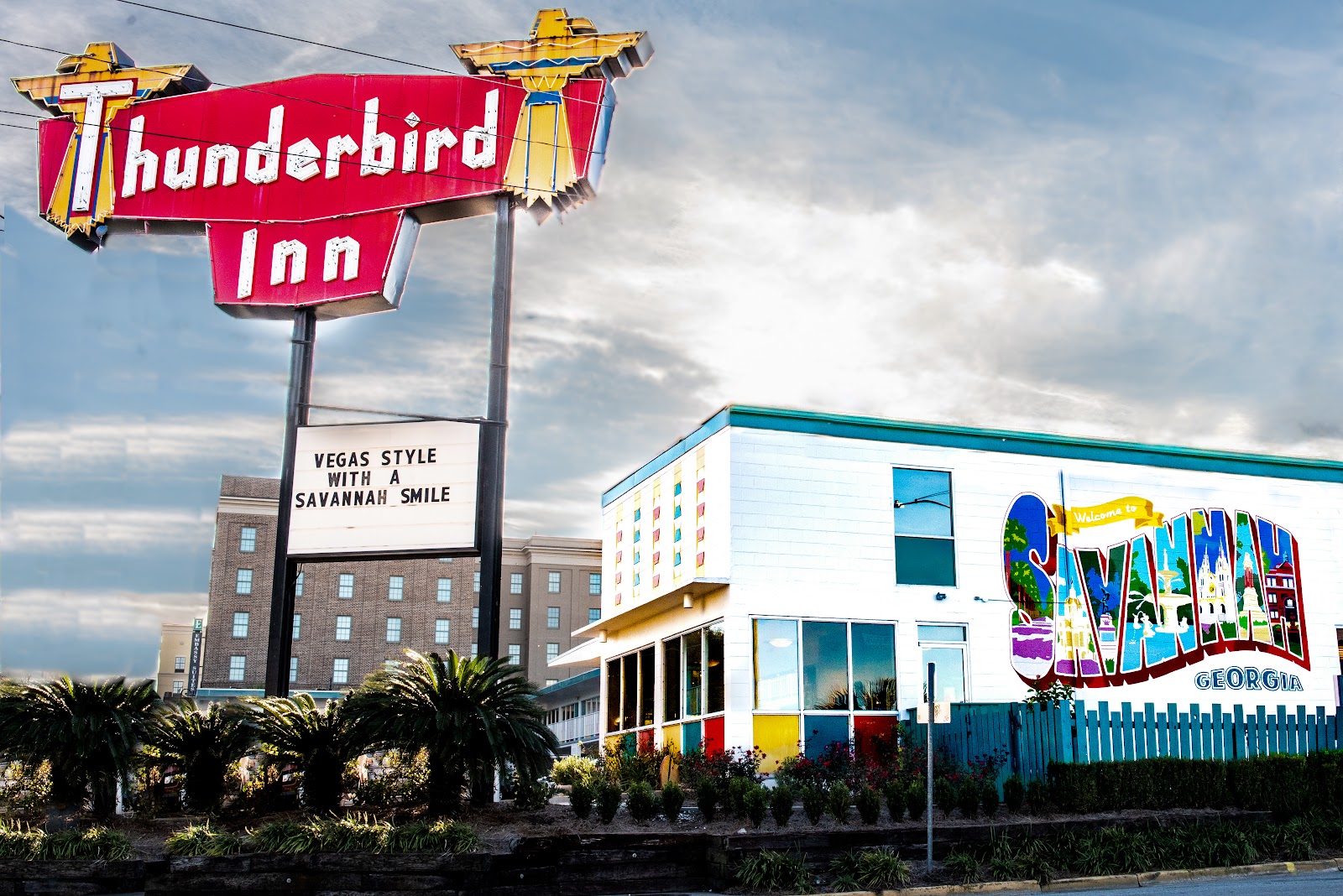 Wedding couple lit by coloured neon signage at the Thunderbird Inn, Savannah