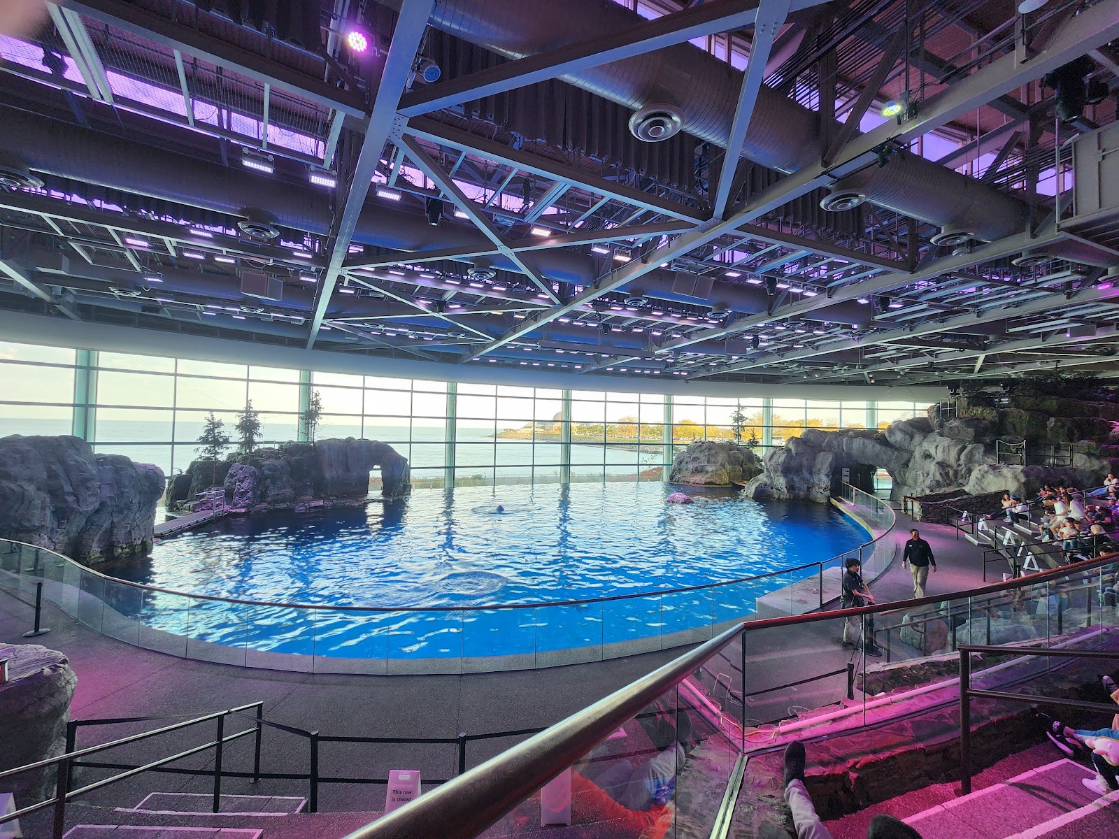 Dim blue-lit aquarium gallery with large viewing tanks